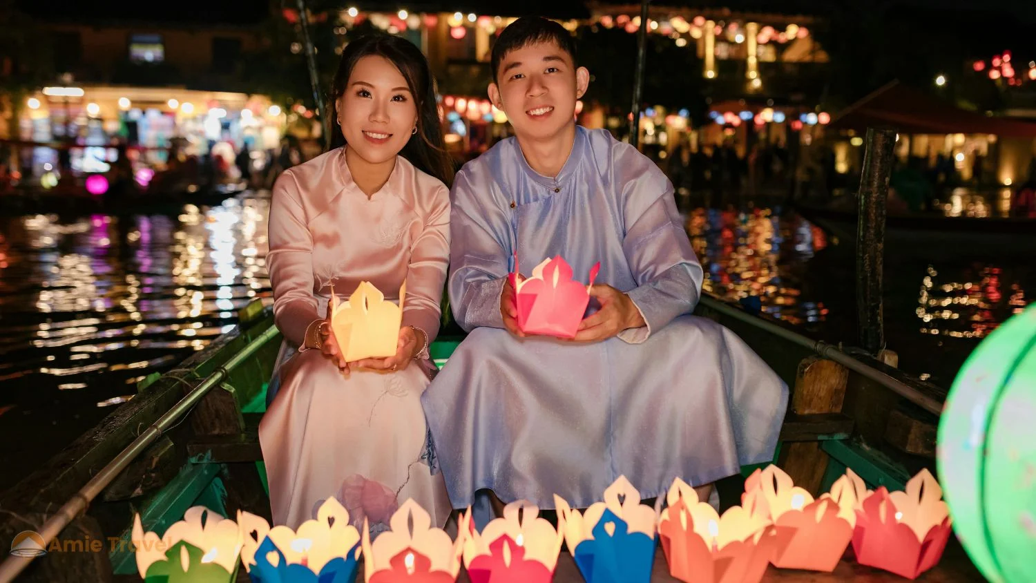 Hoi An Lantern Festival at night, paper lanterns floating on the Thu Bon River, Ancient Town lit by lantern light, warm amber glow, no electric lights